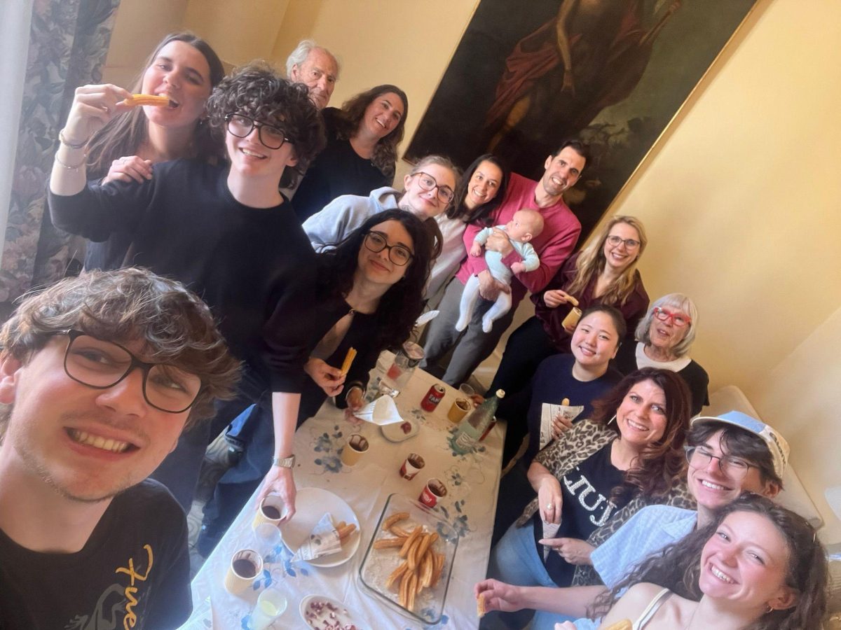 The group gathered around a table with the host family in Barcelona